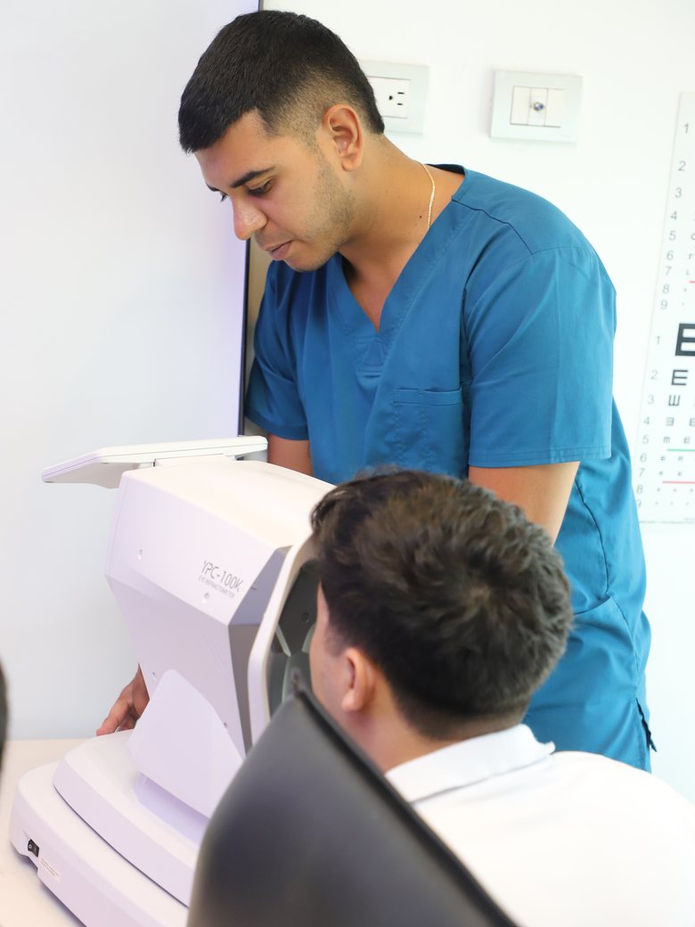 Optómetra de OTIKA realizando examen visual con autorefractómetro en jornada empresarial